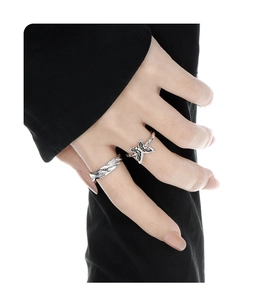 Detail of silver vintage style butterfly ring and textured wave band on model hand