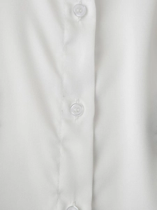 Detailed macro view of white bead-style buttons and cotton fabric texture on a shirt