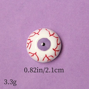 Detail shot of purple eyeball resin accessory with red veins for Halloween DIY crafts