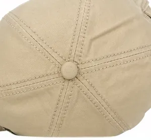 Close-up of precise stitching and top button on a cotton canvas beige baseball cap