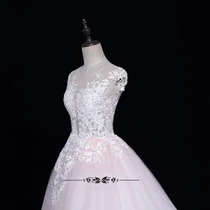 Détail des appliques en dentelle blanche sur le bustier d'une robe de mariée rose