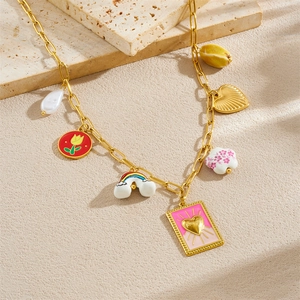 Detailed view of gold plated necklace with baroque pearl, tarot heart, and colorful charms