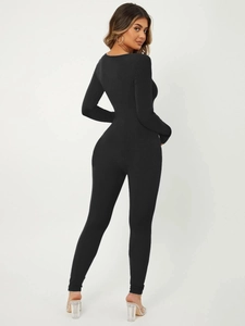 Detail view of the back of a black long-sleeve ribbed jumpsuit for yoga and fitness
