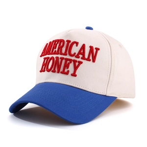 Close-up of American Honey red embroidery on beige and blue trucker baseball cap