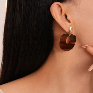 Gros plan de boucles d'oreilles en résine léopard vintage avec fermoir goutte doré