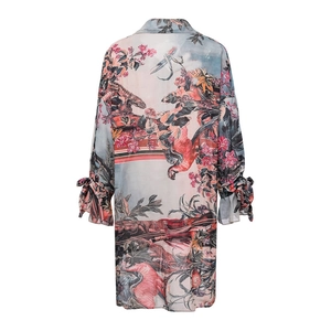 Detail of the tropical print fabric featuring flamingos and chameleon on long sleeves
