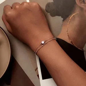 Double-layered 925 sterling silver bracelet with pink heart gemstone on a model's wrist