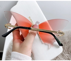 Detail shot of oversized butterfly-shaped rimless sunglasses with gradient lenses