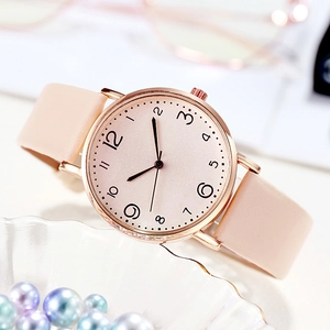 Gros plan d'une montre en cuir rose avec boîtier en or rose et cadran numérique élégant