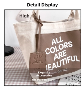 Detail of canvas tote bag with brown leather patch and embossed logo tag texture