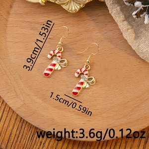 Detail of Christmas candy cane earrings with golden bow and white rhinestones