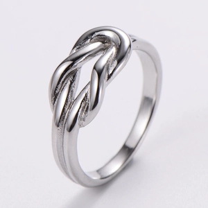 Macro shot of silver knot ring showing detailed metallic texture and polished finish