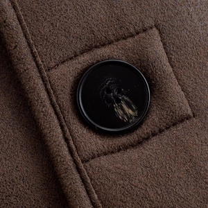 Gros plan sur le bouton et les coutures d'une veste en daim synthétique marron