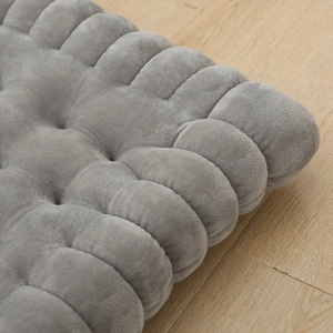 Thickened gray biscuit shaped cushion with velvet texture on light wood floor