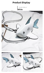 Detail view of mini shark-shaped crossbody bag made of white PU leather with blue fins