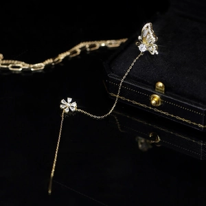 Elegant gold butterfly and flower zircon ear cuff with long tassel chain on jewelry box