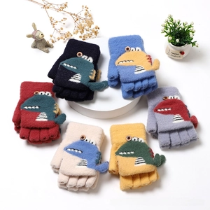 Detail of colorful children's knitted dinosaur gloves with functional flip top and button