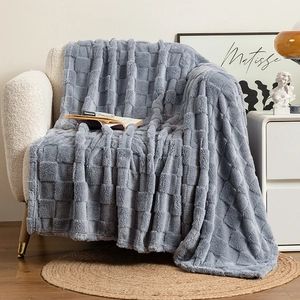 Detail of grey plush checkerboard blanket with textured cubic weave on a sofa