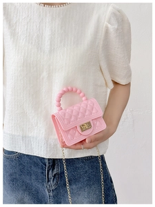 Detailed shot of pink quilted jelly bag featuring pearl handle and golden chain strap