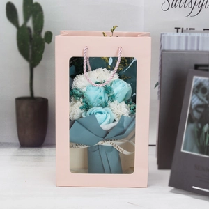 Detail of pink gift bag with blue rose bouquet and for you eternal love ribbon
