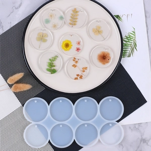 Flat lay of 8-cavity round silicone mold for DIY resin jewelry making on marble