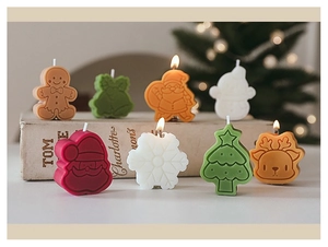 Detail of Christmas candles featuring gingerbread man and Santa shapes on vintage books