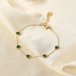 Détail du bracelet en titane plaqué or 14K avec cinq zircons verts en forme de cœur