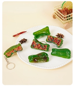 Detailed macro view of realistic PVC stuffed green pepper keychain with burnt skin texture