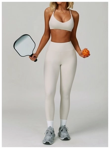 Women's cream white high waist yoga leggings with matching bra and pickleball paddle