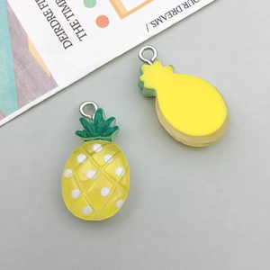 Detailed close-up of pineapple resin pendant with white polka dots and silver metal loop