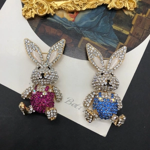 Detailed close-up of rabbit brooches with sparkling pink and blue rhinestones and enamel ears