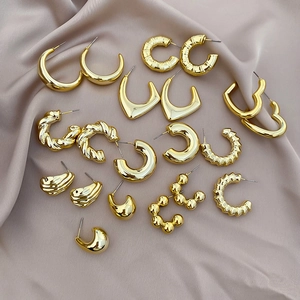 Detailed set of assorted gold-plated geometric earrings on premium silk background