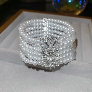 Detailed macro view of a five-layer pearl bracelet with a sparkling crystal square clasp