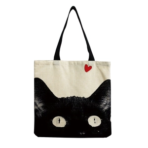 Close-up of cute black cat print with a red heart on beige canvas tote bag