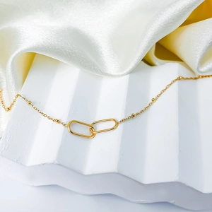 Detail of interlocking oval gold links and beaded chain on minimalist necklace