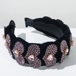 Dettaglio del cerchietto in velluto nero con cuori di cristallo rosa e strass lucenti