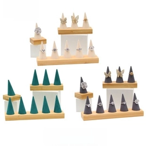 Detail of microfiber ring display sets in green, beige and grey with wooden bases