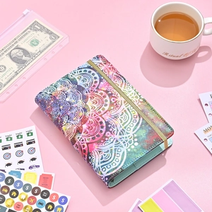 Flat lay of A6 leather cash binder with mandala print, elastic band and budget stickers
