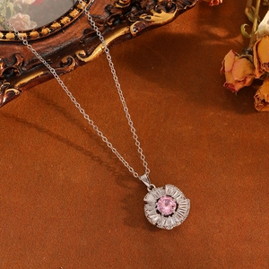 Silberne Blumenkette mit rosa Stein und Kristallen auf vintage braunem Hintergrund