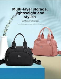 Detail of pink and black nylon handbags with adjustable straps and metal logo detailing