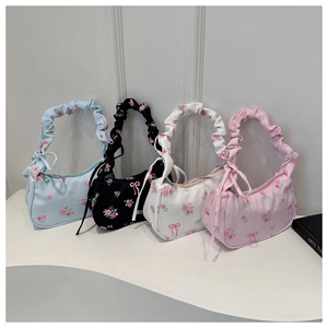 Detailed row of floral print handbags in blue, black, white, and pink with bow accents
