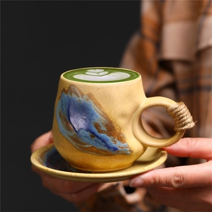 Close-up of handmade ceramic coffee cup with rustic glaze and twine handle detail