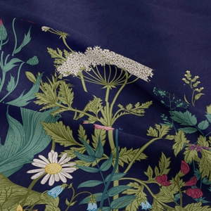 Close-up of bohemian floral tapestry fabric with daisy and berry patterns on navy base