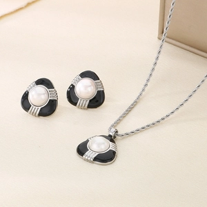 Dettaglio del set di gioielli con perle e smalto nero con catena a maglia argento