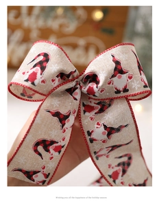 Close-up of rustic Christmas gnome bow with red and black plaid patterns and snow detail