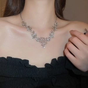 Detail of leaf floral pendant necklace with crystal inlay worn on model neck