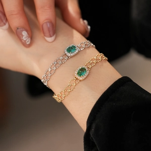 Close-up of vintage bracelet with emerald stones and white zircon in gold and silver plating