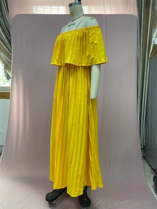 Detail of yellow off-shoulder pleated chiffon maxi dress with ruffled neckline design