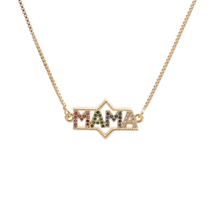 Macro detail of gold necklace with MAMA pendant inlaid with colorful zirconia stones