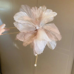 Détail de l'épingle à cheveux fleur en organza lilas avec glands en perles et métal doré